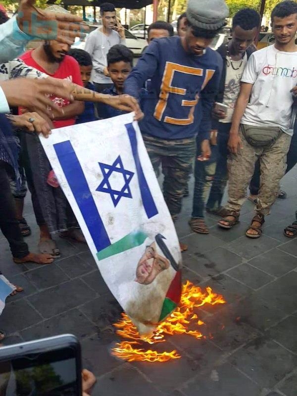 شباب يحرقون علم اسرائيل وصور ابن زايد في عدن